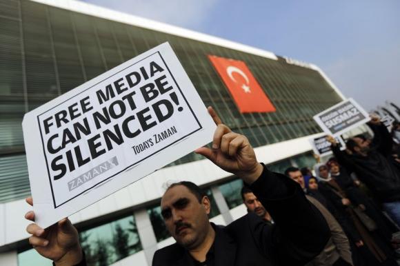 Zaman media group employees hold banners outside the headquarters of Zaman daily newspaper in Istanbul December 14, 2014. REUTERS/Murad Sezer